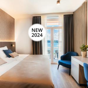 una camera d'albergo con letto, scrivania e finestra di Hotel Riviera - Terme & Wellness Lifeclass a Portoroz