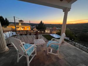 a couple of chairs sitting on a porch with the sunset at Casita rural La cometa in Ruidera