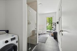 a bathroom with a washing machine and a toilet at Sali-Homes R5 Neubau mit Terrasse im Zentrum in Bayreuth