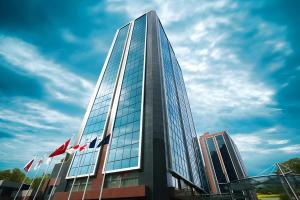 a tall glass building with flags in front of it at Byotell Istanbul in Istanbul