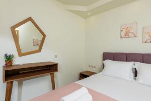 a bedroom with a bed and a mirror at Villa Roula in Koinyra