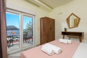 a bedroom with a bed and a mirror and a window at Villa Roula in Koinyra