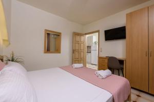 a bedroom with two beds and a desk and a tv at Villa Roula in Koinyra