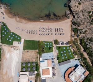 uma vista aérea de uma praia com um sinal que indica gaiola ecológica para ovos de tartaruga marinha em Plaka Beach Resort em Vasilikos