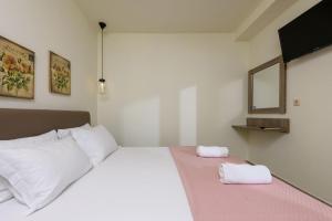 a bedroom with a bed with two towels on it at Villa Roula in Koinyra