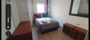 ein kleines Schlafzimmer mit einem Bett und einem Spiegel in der Unterkunft Primera Linea De Playa in Roquetas de Mar + 19 Fotos