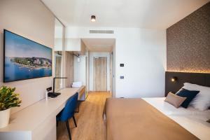a hotel room with a bed and a desk at Hotel Riviera - Terme & Wellness Lifeclass in Portorož