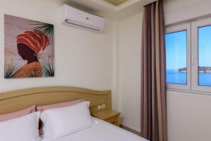 a bedroom with a bed and a large window at Villa Roula in Koinyra