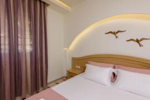 a bedroom with a white bed and a window at Villa Roula in Koinyra