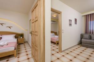 a bedroom with a bed and a mirror and a chair at Villa Roula in Koinyra