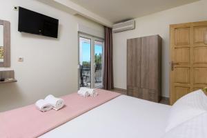 a bedroom with a large bed with two towels at Villa Roula in Koinyra
