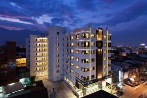 花莲市Ramada Encore By Wyndham Hualien的夜晚在城市里高大的白色建筑