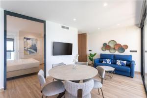 a living room with a table and a blue couch at ARENAL SUITES BENIDORM in Benidorm