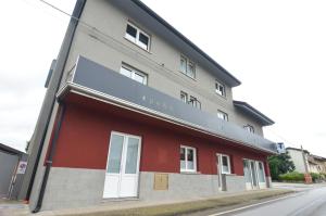 ein rot-graues Gebäude an einer Straße in der Unterkunft Spe&d in Rivis