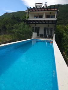 代诺维奇VanjAna 1的一栋房子前面有游泳池的别墅