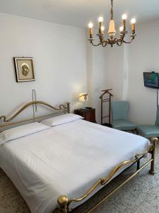 a bedroom with a bed with a chandelier and two chairs at Bed & Breakfast Casa Marinella in Lenna
