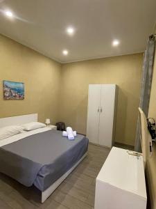 1 dormitorio con 1 cama y armario blanco en Royal Dante, en Nápoles