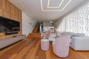 a living room with a couch and chairs and a tv at Villa Calla ZadarVillas in Petrcane