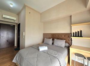 um quarto com uma cama grande num quarto em Apt Casa De Parco Studio Tema Gray With Wifi, Pool and Netflix em Samporo