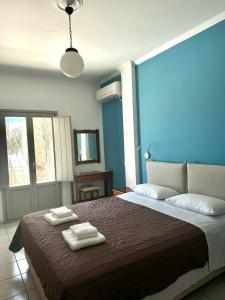 カマリにあるSail Inn Studios & Apartmentsの大きなベッドとタオル2枚のある寝室