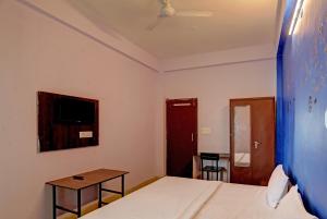 um quarto com uma cama, uma mesa e um espelho em Hotel Sambodhi Palace em Bhopal