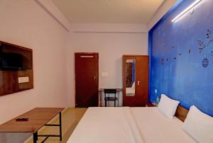 a bedroom with a large bed and a table at Hotel Sambodhi Palace in Bhopal