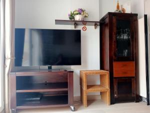 ein Wohnzimmer mit einem großen Fernseher und einem Entertainment-Center aus Holz in der Unterkunft Primera Linea De Playa in Roquetas de Mar