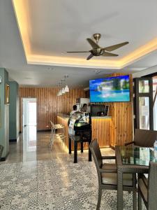 Aloha Residence في شاطئ كاتا: غرفة معيشة مع مروحة سقف وطاولة