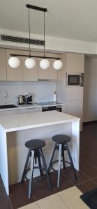 eine Küche mit zwei Barhockern und einer Arbeitsplatte in der Unterkunft Vitas Apartments in Zaton