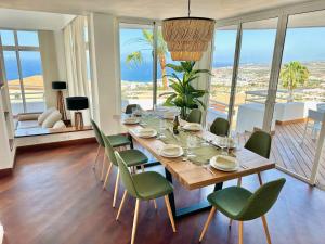 a dining room with a table and green chairs at Luxury Villa Taoro private heated pool Free Car Except Christmas in Adeje