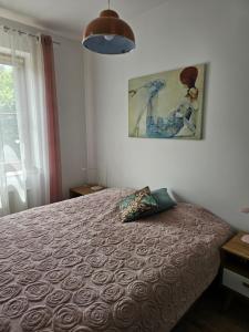 a bedroom with a bed and a painting on the wall at Apartament 16 - Bliżej Zdroju in Polanica-Zdrój