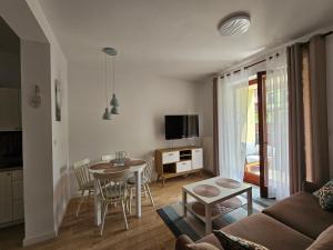 a living room with a couch and a table at Apartament 16 - Bliżej Zdroju in Polanica-Zdrój