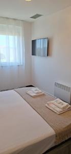 ein Schlafzimmer mit einem großen Bett mit zwei Handtüchern darauf in der Unterkunft Vitas Apartments in Zaton