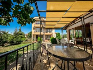 een patio met een tafel en stoelen op een balkon bij Guest House Moiata Kashta in Chernomorets