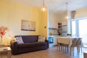 sala de estar con sofá y mesa en Blu Sun Apartment in Complesso Riva del Sole, en Giovinazzo