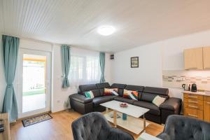 una sala de estar con un sofá y una mesa en Menta Apartman, en Siófok