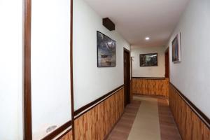 um corredor com painéis de madeira e quadros nas paredes em OYO The Stay em Ballygunge