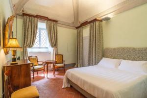 sypialnia z łóżkiem, stołem i krzesłami w obiekcie Palazzo Nobile di San Donato w mieście Montepulciano