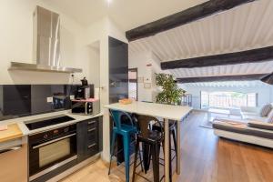 a kitchen with a counter and a table with chairs at Appart Hypercentre CLIM 2chb QuartierChic in Aix-en-Provence