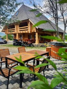 a wooden cabin with a picnic table in front of it at Pensiunea Casa Cătanelor in Leordina +34 photos