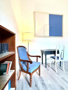uma sala de estar com uma cadeira e uma secretária em ComeCasa near Piazza Vittorio 2 Bedrooms em Turim