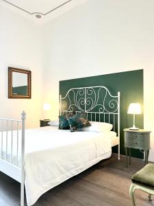 um quarto com uma cama branca e uma cabeceira em preto e branco em ComeCasa near Piazza Vittorio 2 Bedrooms em Turim
