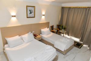 亚历山大Regency Hotel Alexandria的有两张床和一扇窗户的酒店房间
