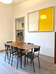 uma sala de jantar com uma mesa de madeira e cadeiras em ComeCasa near Piazza Vittorio 2 Bedrooms em Turim
