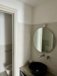 a bathroom with a black sink and a mirror at Hotel CineApollo - Ogni camera un film! in Messina