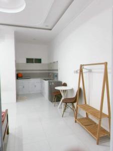 a white kitchen with a table and a chair at Hoàng Hà homestay in Ấp Khánh Phước (1)