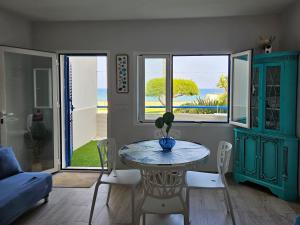 a living room with a table and chairs and windows at Mojácar Vibes 1 Línea de Playa in Mojácar