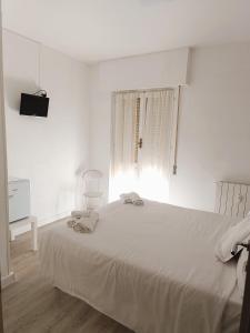 Habitación blanca con cama y ventana en Hotel Bacco Rooms and Breakfast, en Pietra Ligure