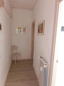 un corridoio con termosifone e sedia in una stanza di Hotel Bacco Rooms and Breakfast a Pietra Ligure