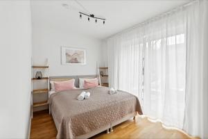 um quarto com uma cama com almofadas cor-de-rosa e uma janela em Sali Homes R3 Gemütlichkeit am Rother Mainufer em Bayreuth
